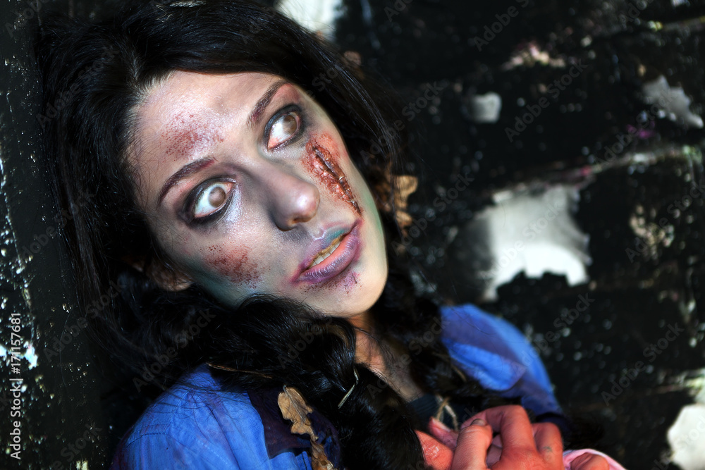 Fototapeta premium young zombie girl with traces of facial decomposition