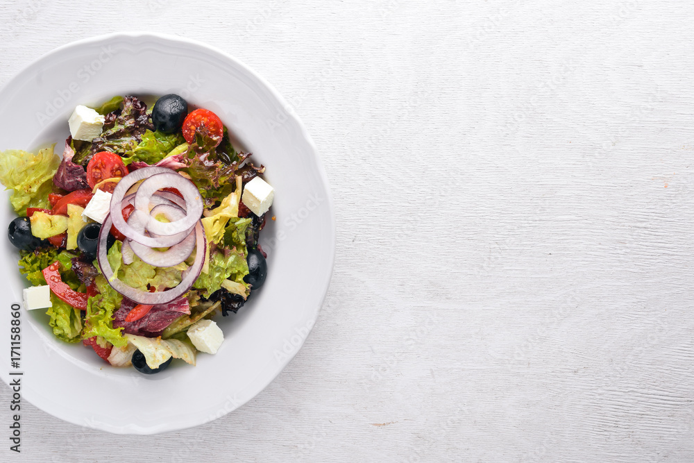 Greek salad. Fresh vegetables on a wooden background. Top view. Free space for text.