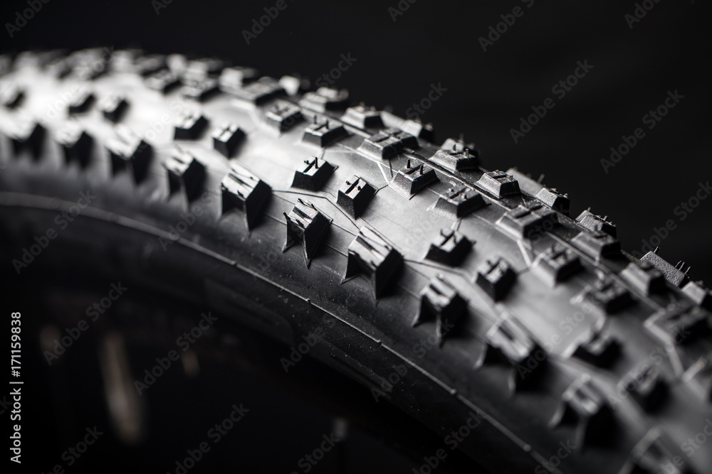 Naklejka premium Modern MTB race mountain bike tyre isolated on black background in a studio