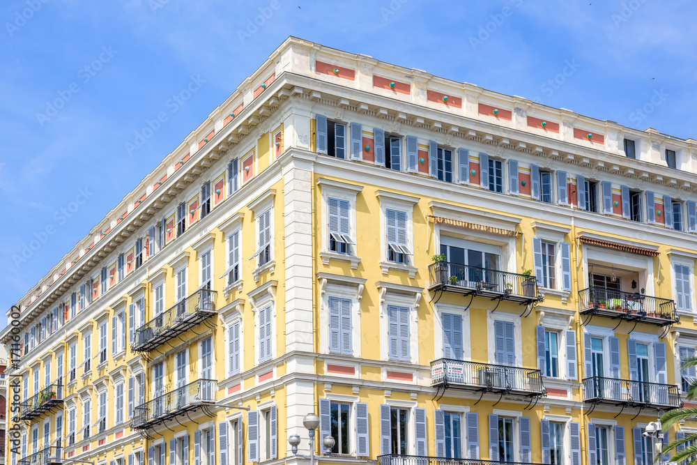 Daylight view to yellow building of a hotel in Nice Cote d'Azur, France. Blue sky background.