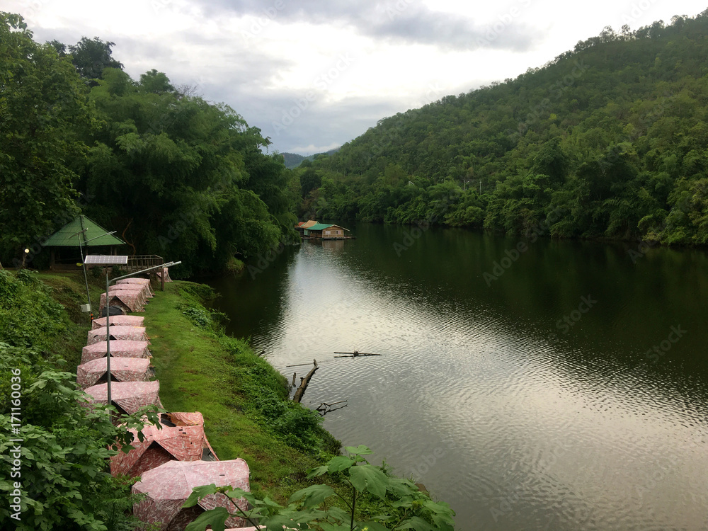 Fototapeta premium Camping area along side Khwae Yai River at Erawan waterfall - Kanchanaburi, Thailand