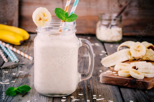 banana smoothie with oatmeal in mason jar on a wooden background