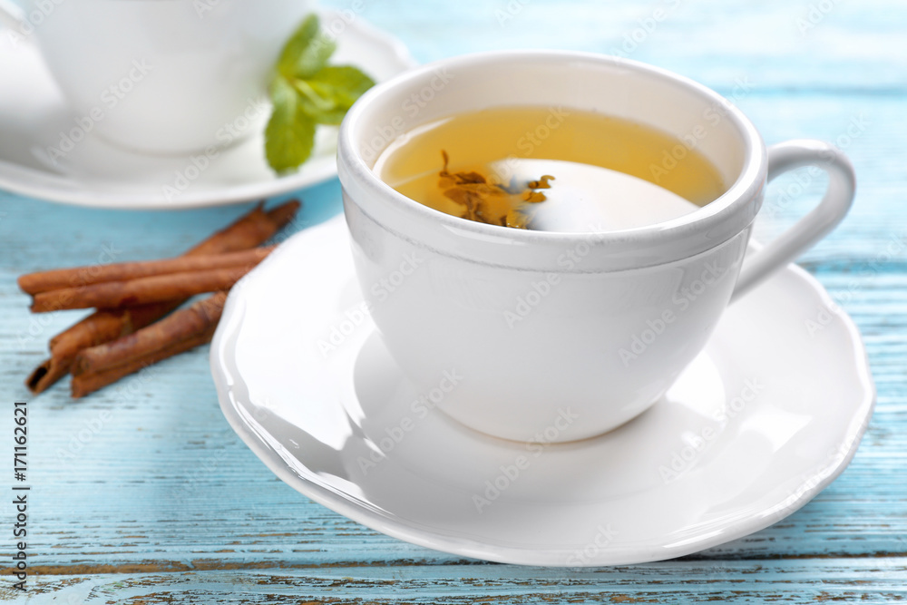 Beautiful composition with cup of cinnamon tea on wooden table Beautiful composition with cup of cinnamon tea on wooden table