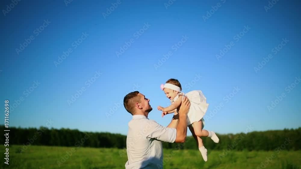 Father playing with little daughter throws on their hands. Father playing with little daughter throws on their hands.