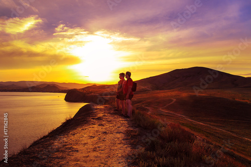 Two tourists walk across the hills. © lizavetta