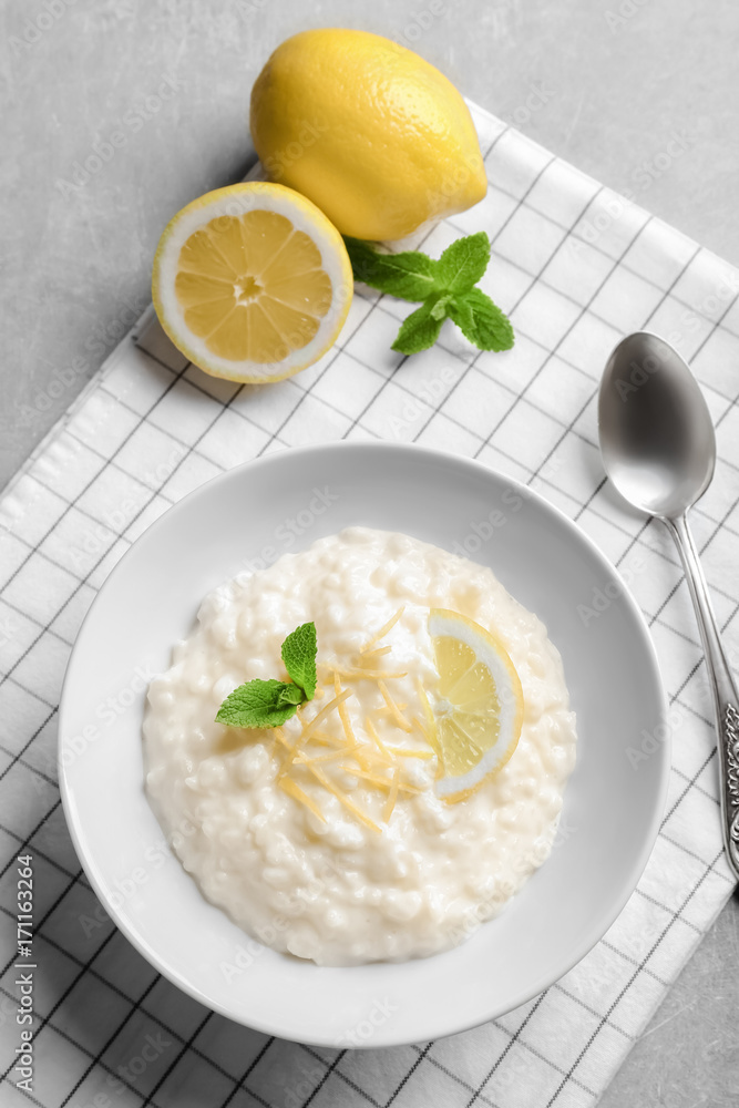 Creamy rice pudding with lemon in plate on table Creamy rice pudding with lemon in plate on table