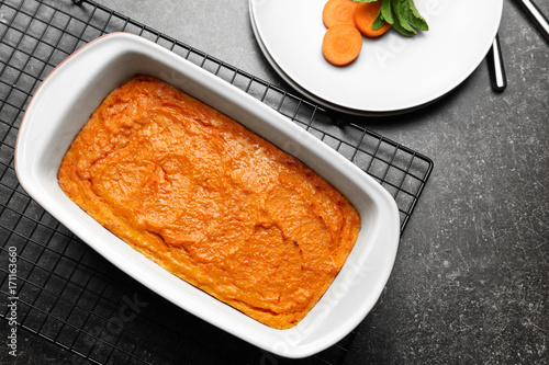 Baking dish with tasty carrot souffle on table