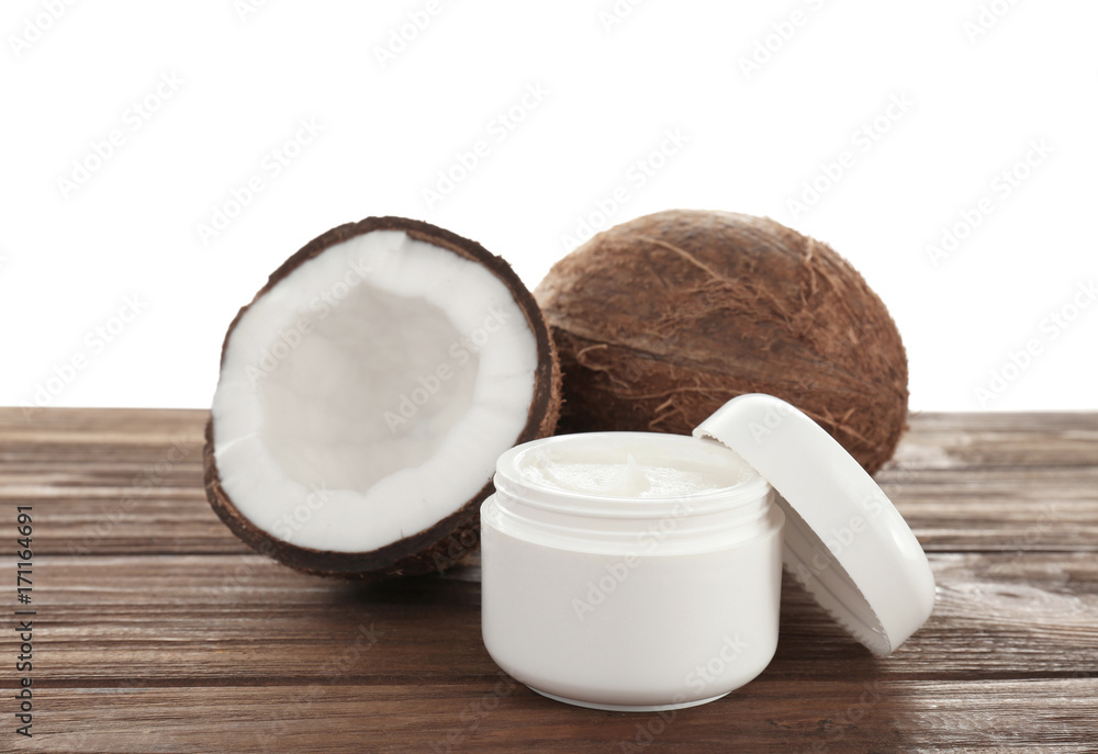 Coconut oil in jar on table against white background Coconut oil in jar on table against white background