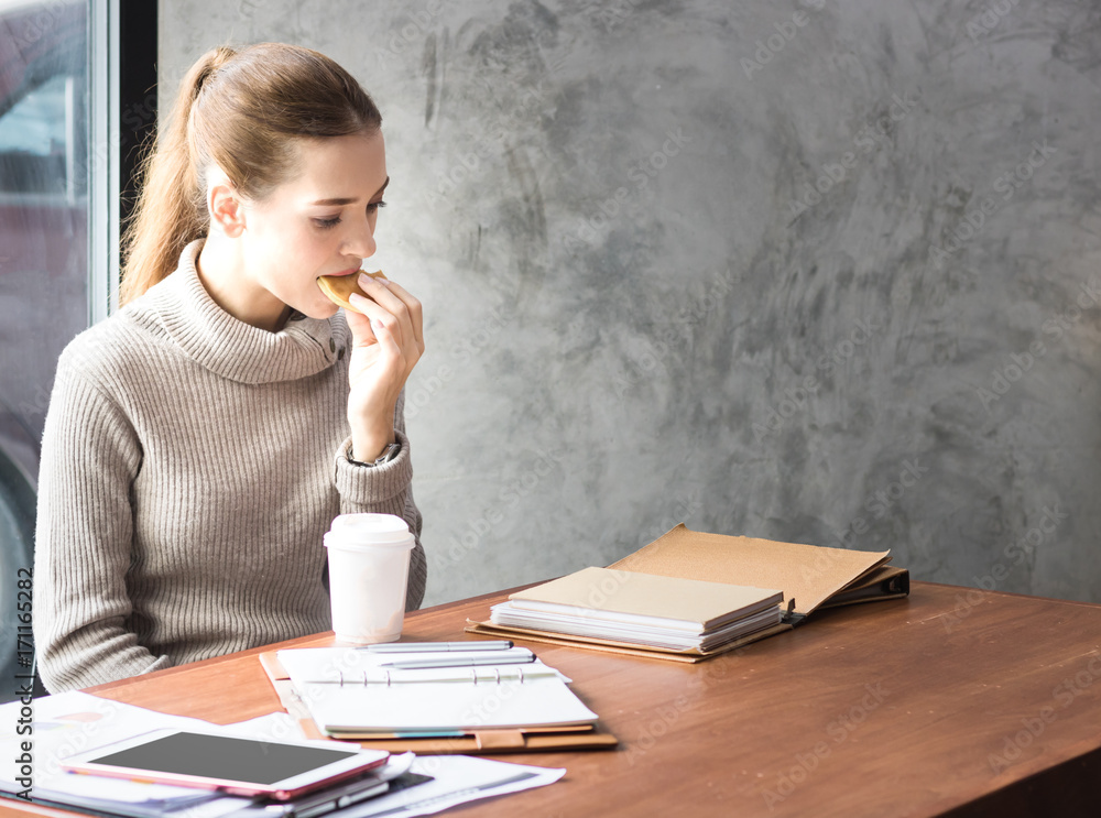 business women eat bread drink coffee with reading book in morning business women eat bread drink coffee with reading book in morning