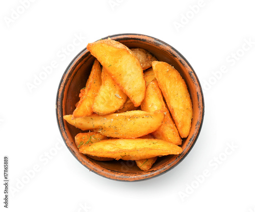 Bowl with delicious baked potato wedges on white background