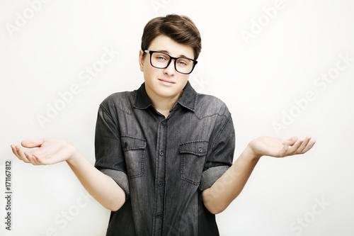 Young man in glasses feeling confused isolated on white