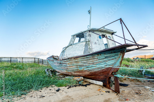 an old wooden ship stands on a sandy beach