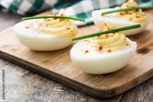 Stuffed eggs with mustard,mayo and paprika  on wooden table

