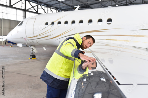 Foto check/ Inpsektion Flugzeug im Hangar am Flughafen dirch Bodenpersonal - Mechanik