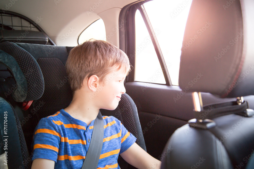 Boy sitting in a car in safety chair.
