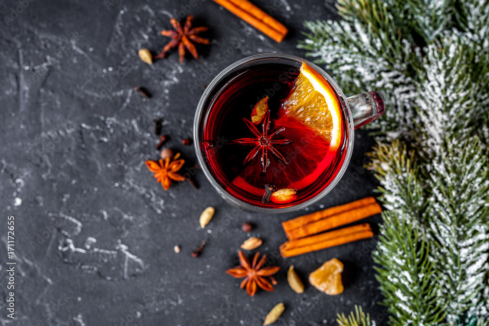 Christmas mulled wine with spices in cup on dark background