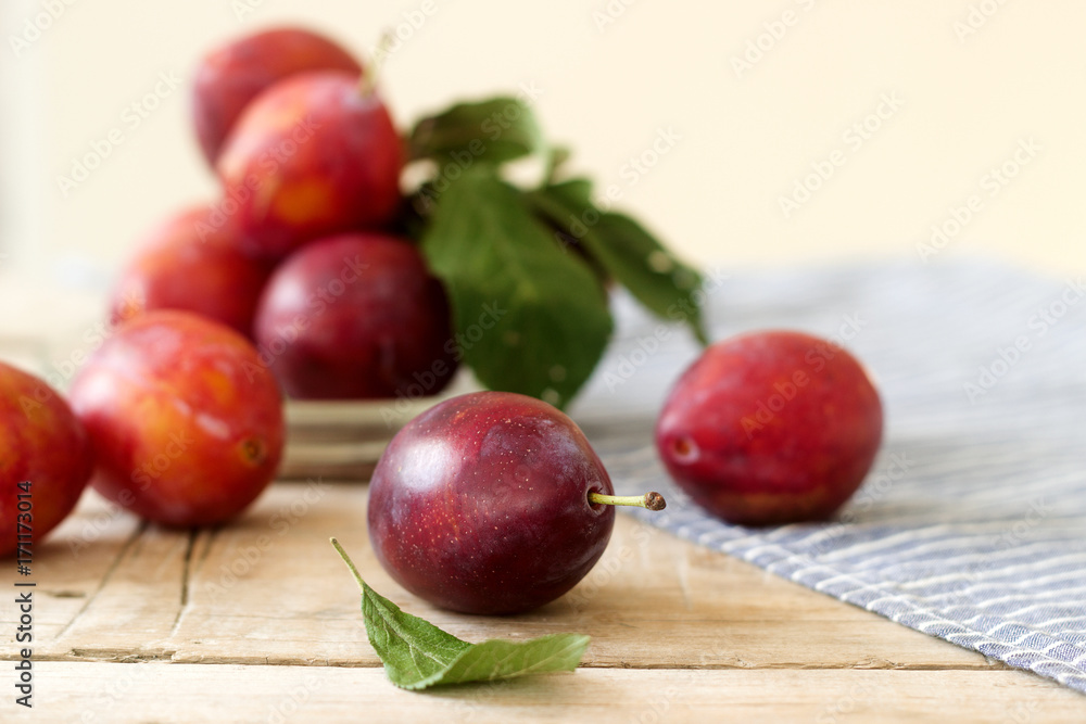 Plums in a plate on a wooden table, rustic style, selective focus. Plums in a plate on a wooden table, rustic style, selective focus.