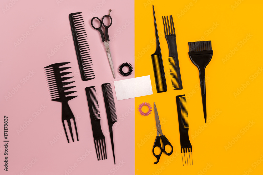 Fototapeta premium Hairdresser tools on pink and yellow background with copy space, top view, flat lay.