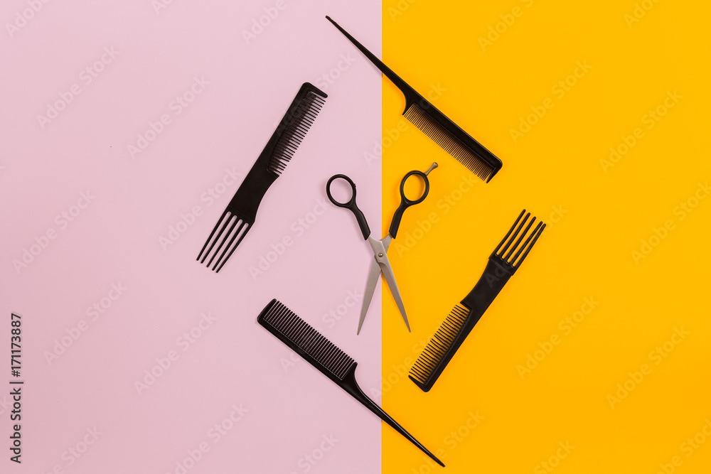 Barber set with combs and scissors on pink and yellow background Barber set with combs and scissors on pink and yellow background