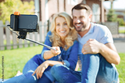 Cheerful couple taking selfies with a selfie stick