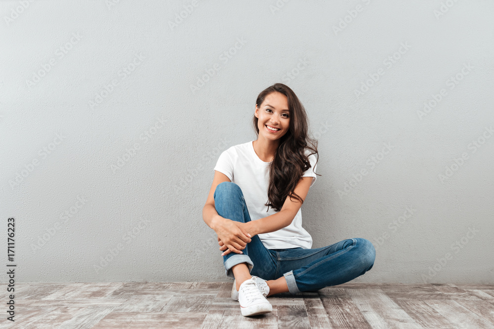 Happy pretty asian woman sitting and looking at camera Happy pretty asian woman sitting and looking at camera