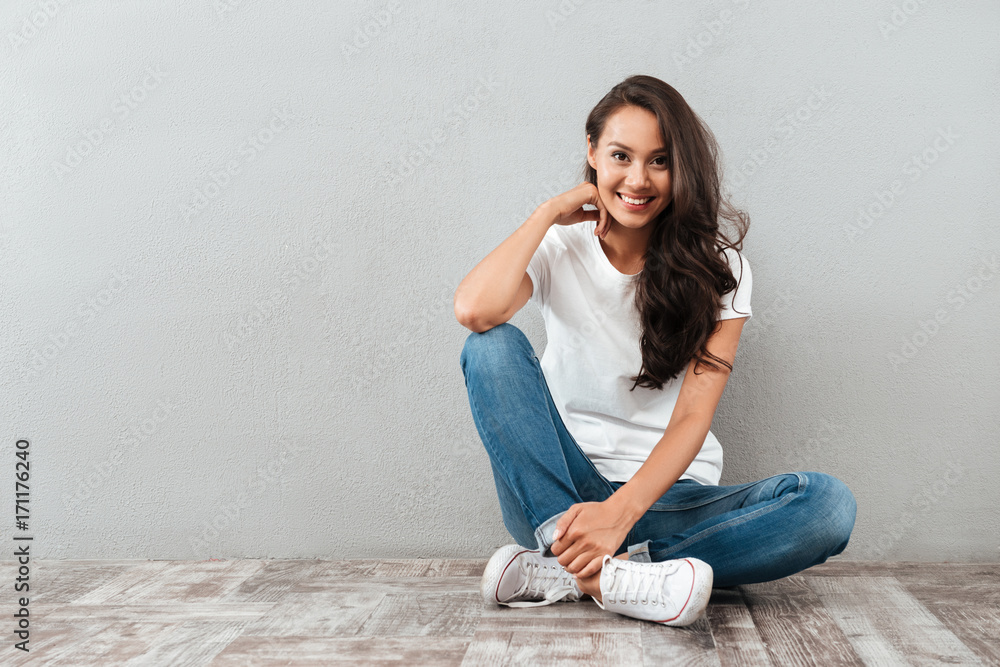Joyful pretty asian woman sitting on the floor Joyful pretty asian woman sitting on the floor