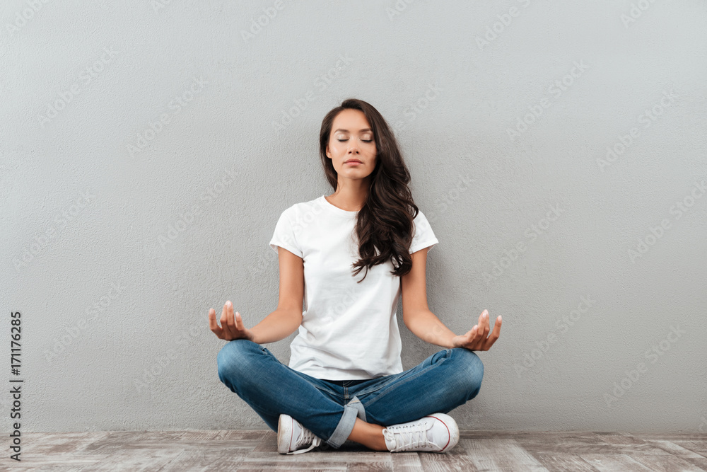 Beautiful young asian woman sitting in yoga position and meditating - obrazy, fototapety, plakaty 