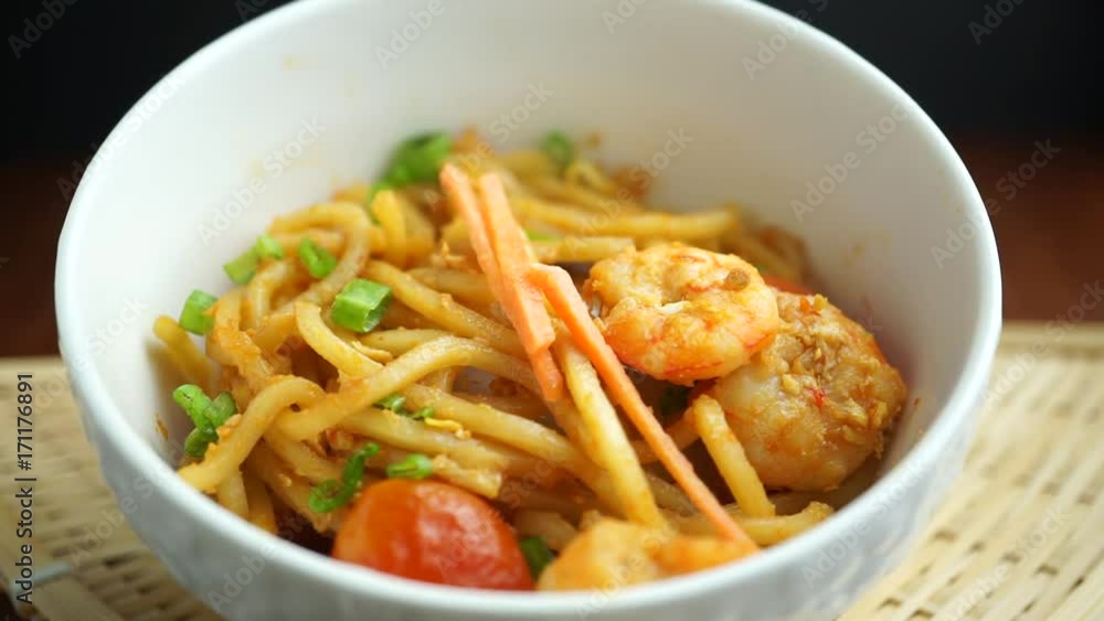 sprinkle orange carrot slice on Hokkien mee or Chinese fried noodle