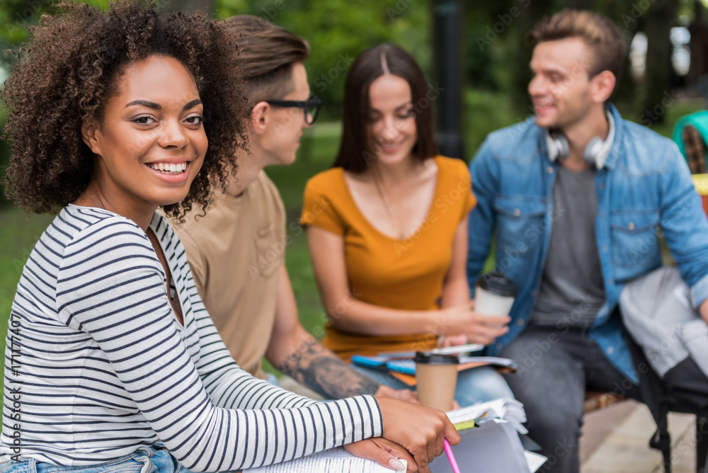 Fototapeta premium Cheerful young students talking in park