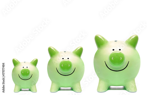 Vászonkép Three green piggy banks in different sizes / Green business and grown concept