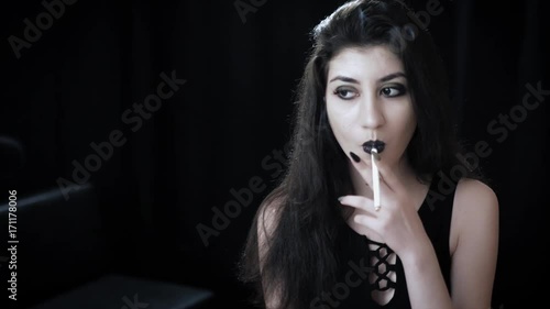 Goth girl with black eyes occasionally prefers dragging a 120mm cigarette. In this new video you can watch her looking straight into the camera, taking deep whiffs, skillfully flicking ash 