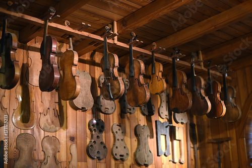 Violins hanging in luthier workshop photo