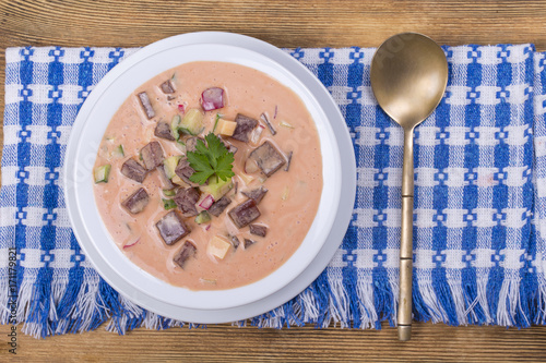 Cold borscht - speciality for hot summer days. Vegetable cold soup with beet, cucumber, potato, radsih and egg . Close up photo