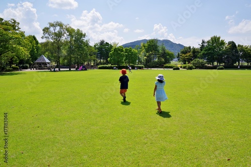 夏の芝生の公園を歩く子供