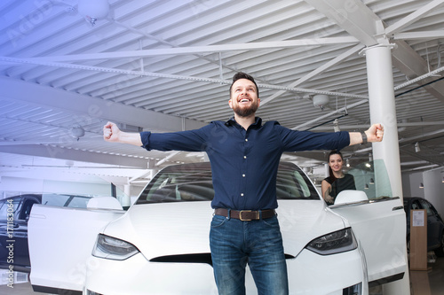 man chooses the car in the showroom