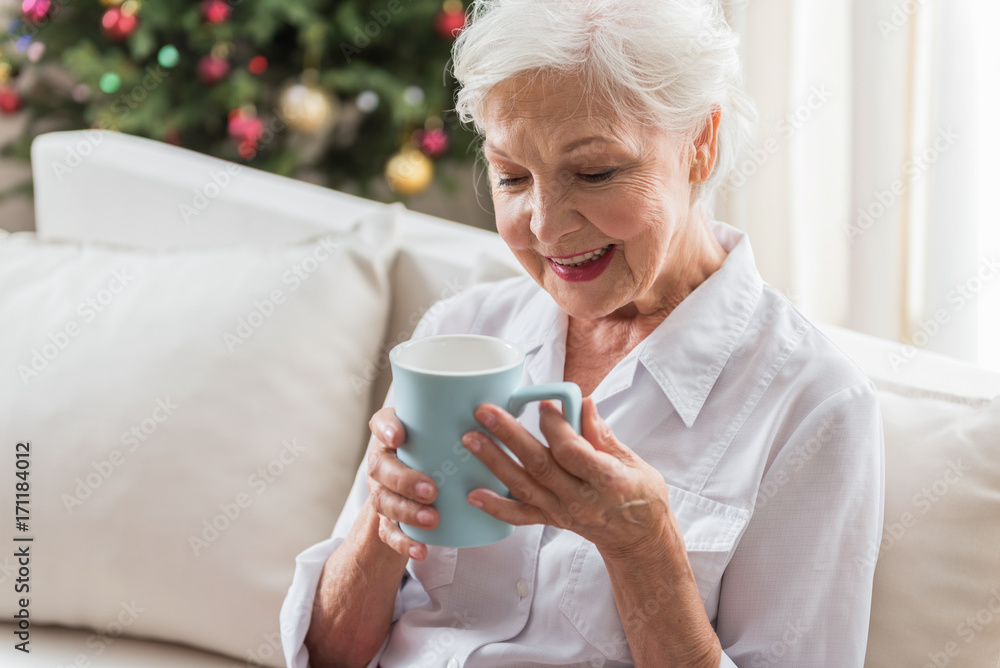 Cheerful old woman is smelling aromatic tea Cheerful old woman is smelling aromatic tea