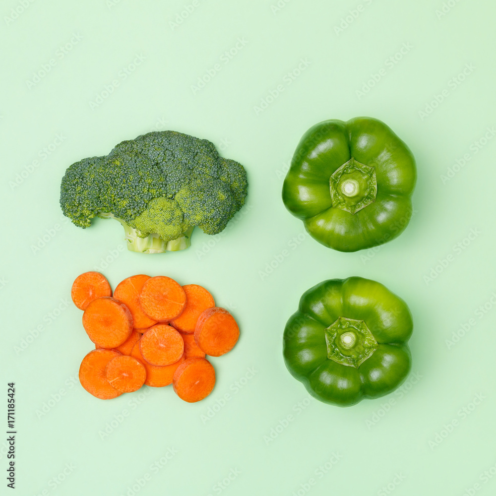 Top view of broccoli, green pepper, sliced carrot on a pastel green background. Set of seasonal vegetables. Minimal concept. Vegan food Top view of broccoli, green pepper, sliced carrot on a pastel green background. Set of seasonal vegetables. Minimal concept. Vegan food