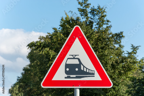 A triangular street sign for train tracks