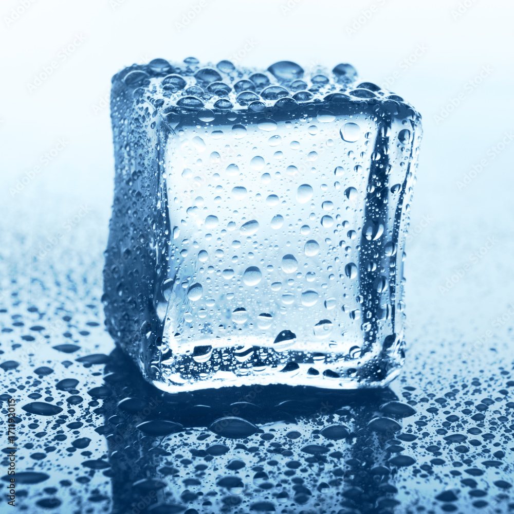Transparent ice cube on blue glass with water drop Transparent ice cube on blue glass with water drop