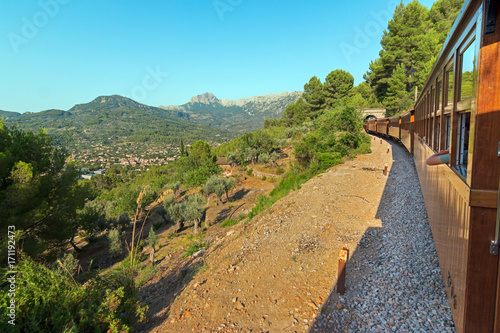 Soller wooden train driving through the Serra de Tramuntana mountains range and entering in a tunnel