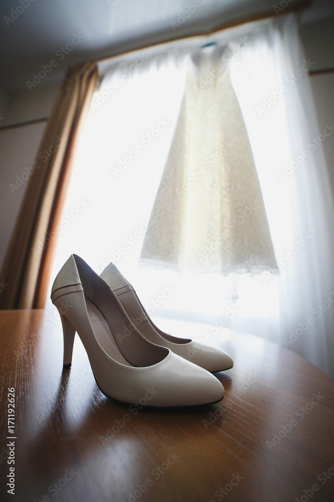 Wedding shoes and dress on the background