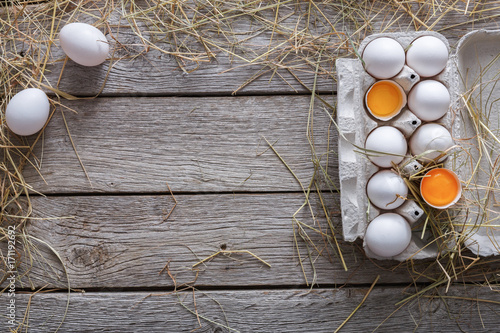 Fresh white eggs in carton on rustic wood background