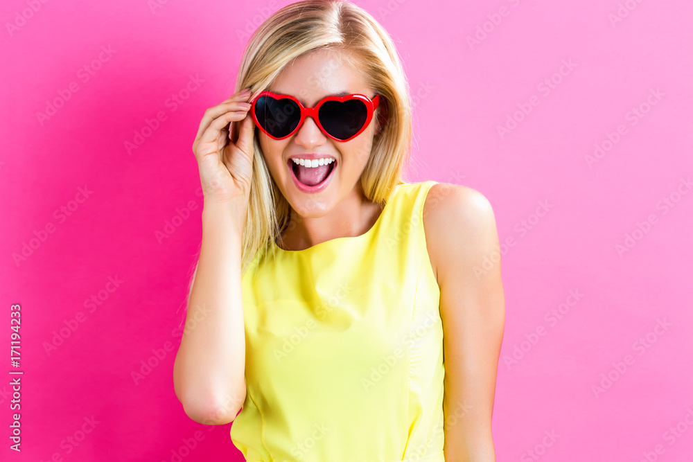 Young woman with sunglasses on a pink background Young woman with sunglasses on a pink background
