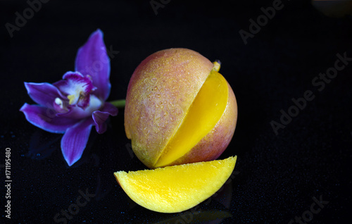 mango on a dark wood background. tinting. selective focus on the mangos slices photo