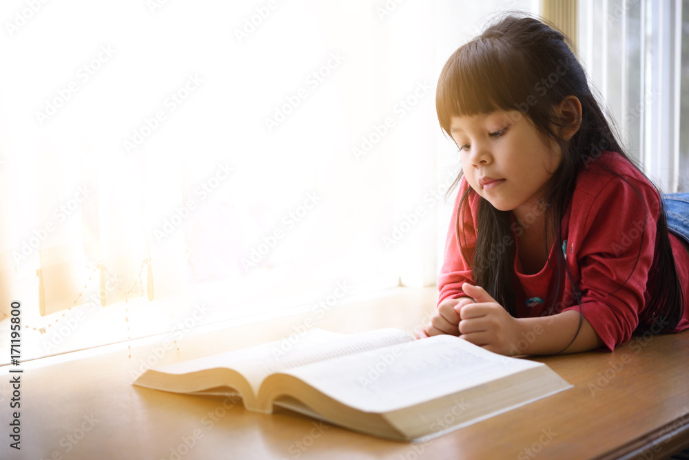 Funny little girl reading a book library or a book store. Funny little girl reading a book library or a book store.