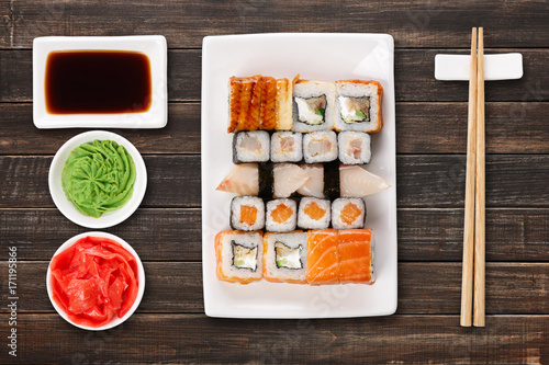 Set of sushi, maki and rolls on brown wooden background
