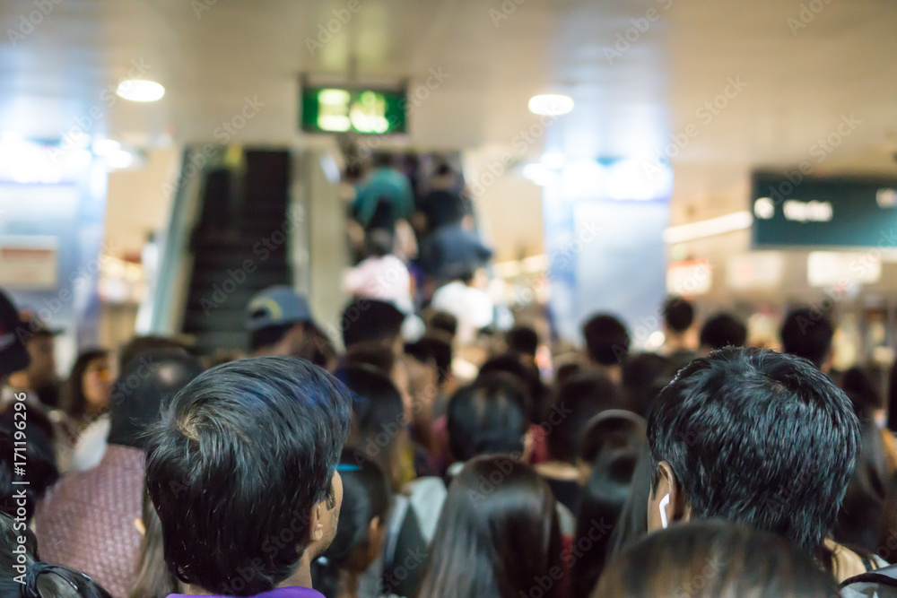 Crowded Asian people queue for escalator to exit from public subway during rush hour