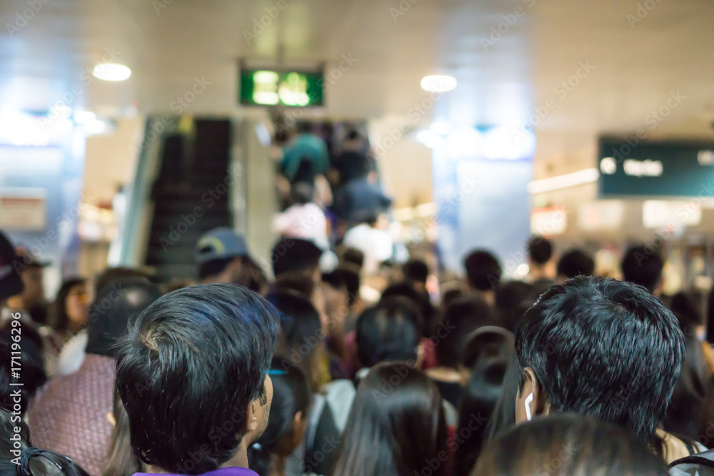 Crowded Asian people queue for escalator to exit from public subway during rush hour Crowded Asian people queue for escalator to exit from public subway during rush hour