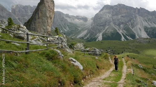 Women makes a hike and goes up the path in a mountainous area photo