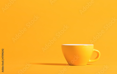Little yellow teacup on a bright background